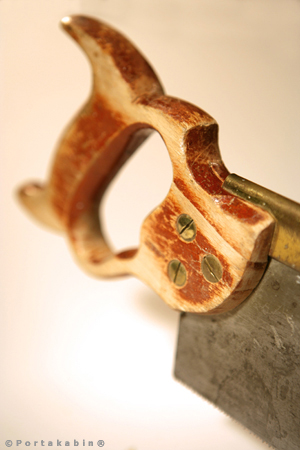 Backsaw with brown handle on white background in soft focus. Conceptual Photography by David Barr
