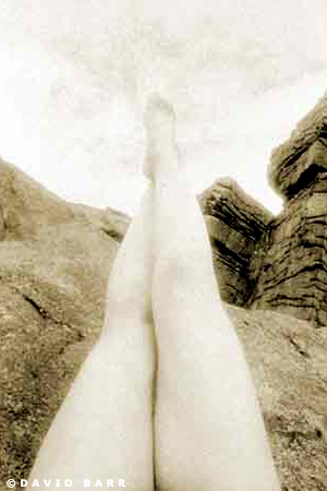 Girls legs pointing up to the sky with Brimham rocks in background. Conceptual Photography by David Barr